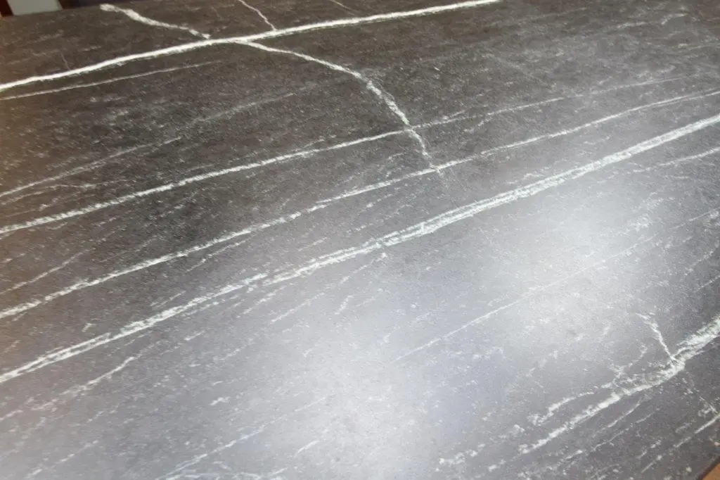 Close-up of a dark grey marble surface with white veining and natural patterns across it.