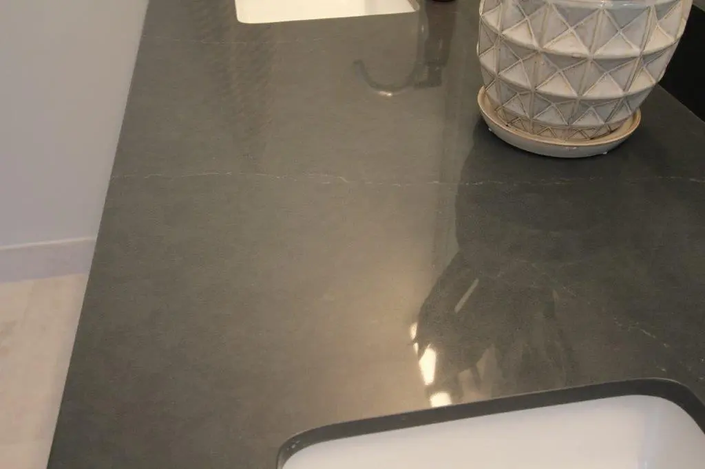 Dark gray polished countertop with a patterned ceramic planter and a built-in sink.