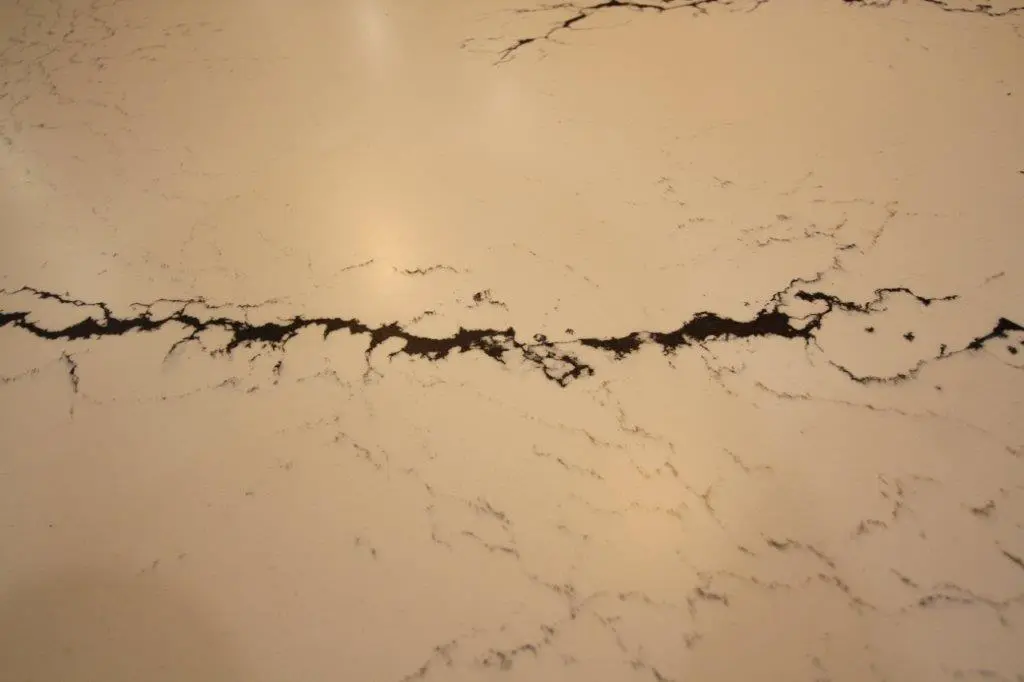Close-up of a white quartz surface with black veining in an irregular pattern across the stone.