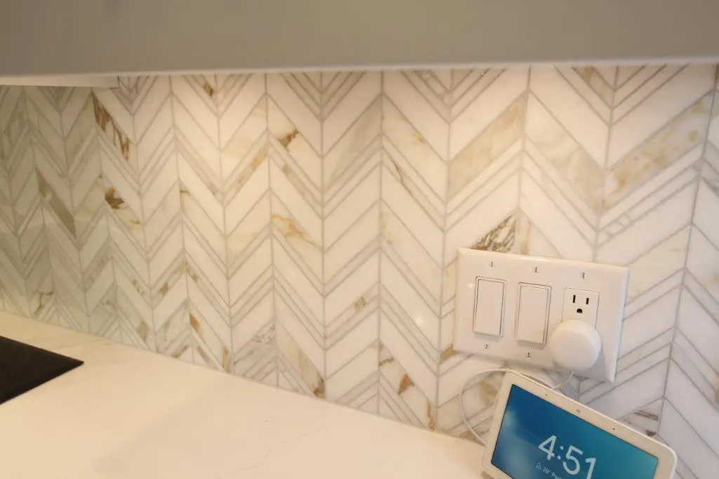 Chevron-patterned backsplash with white and tan tones.