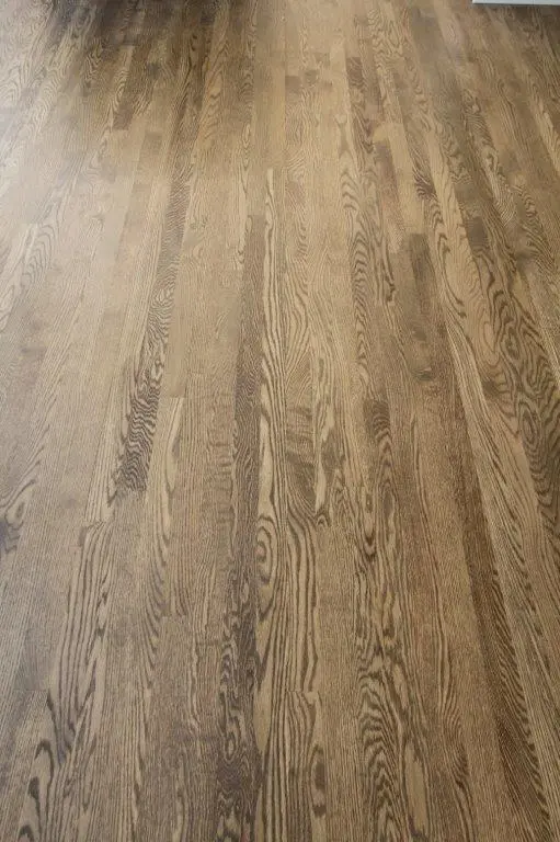 Close-up view of a wooden floor with distinct grain patterns and a natural brown finish.