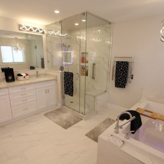 Spacious modern white bathroom with double-sink vanity, glass-enclosed shower, built in tub with wooden tray, and decorative lighting