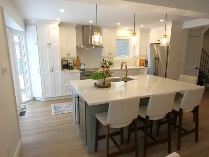 Bright modern kitchen with white cabinets, a large island, pendant lights, and four bar stools