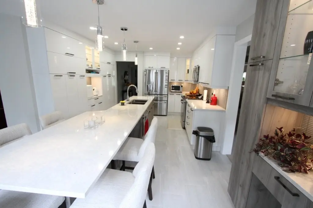 Bright modern white kitchen with an island, stainless steel appliances, and pendant lights