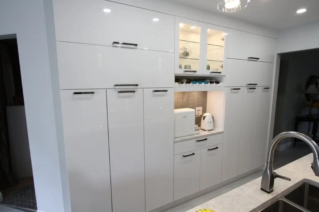 Built-in white kitchen cabinets with a hidden appliance nook and coffee station