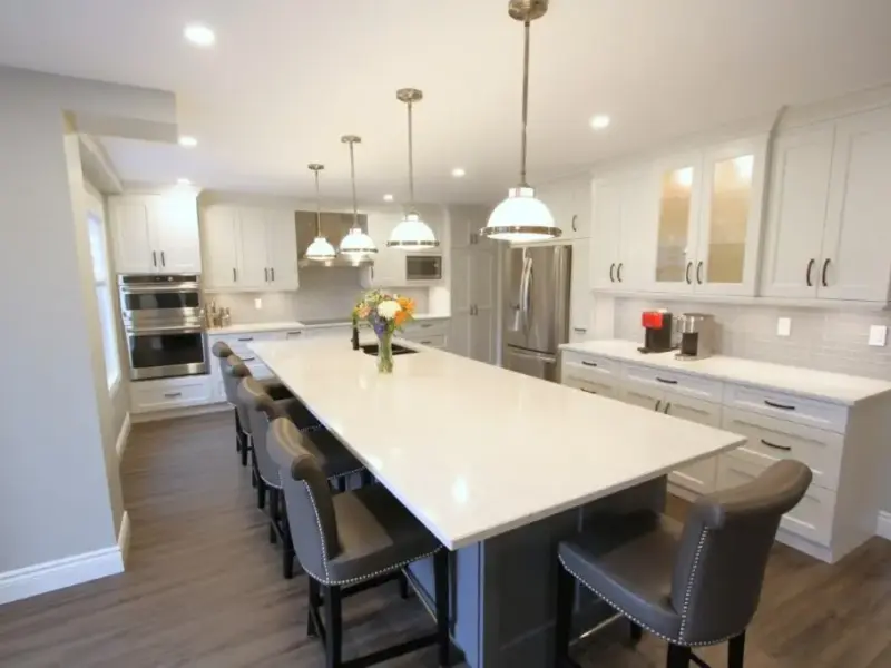 Modern white kitchen with a large island, pendant lights, and bar stools