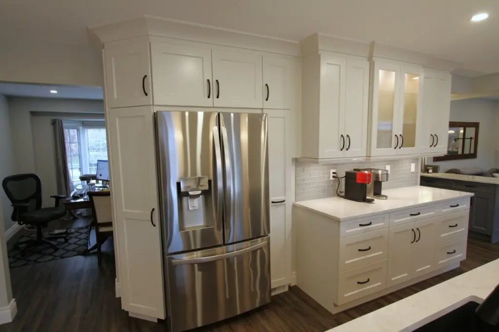 Modern kitchen with white cabinets, stainless steel refrigerator, and coffee maker on the counter