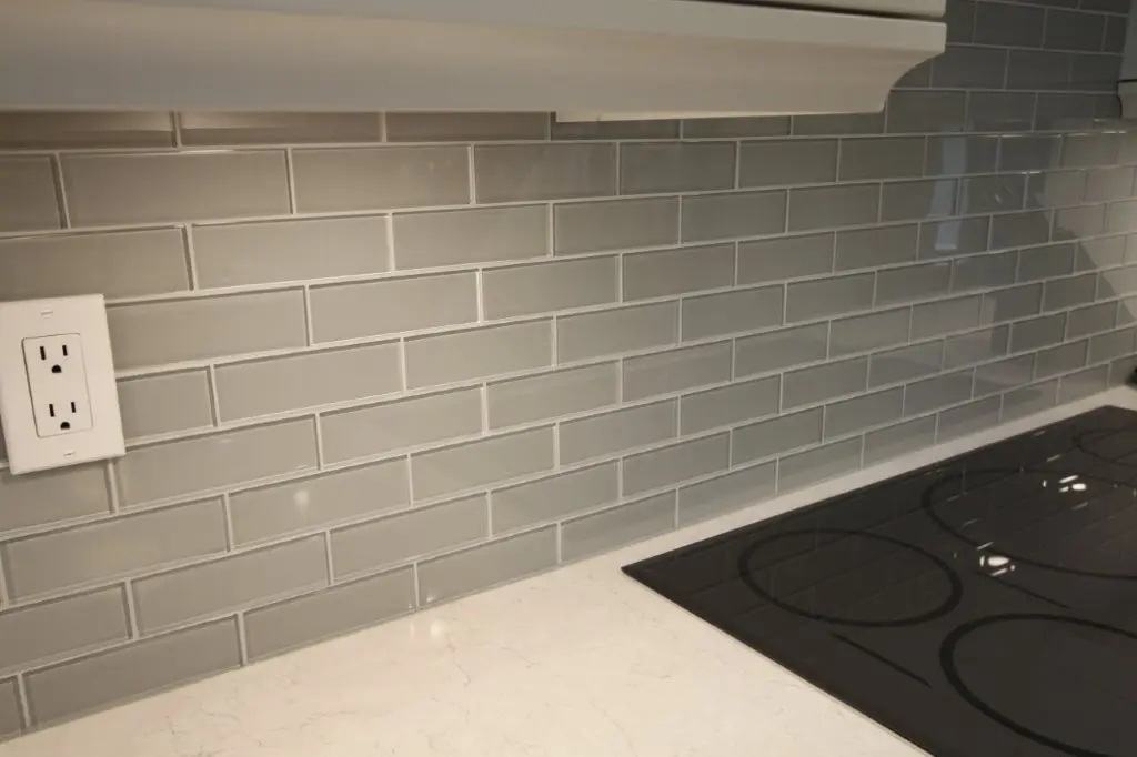 Kitchen backsplash with an outlet beside a countertop and electric cooktop